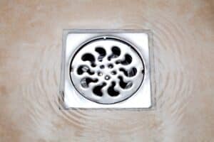 water flowing over into metal floor drains