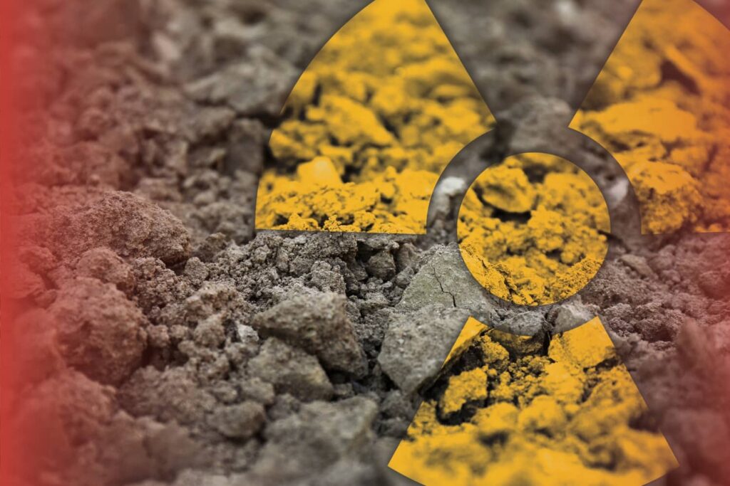 What Are Acceptable Radon Levels By State? 1 A yellow radiation symbol overlaid on cracked soil illustrating soil gas risks for an article on acceptable radon levels by state.